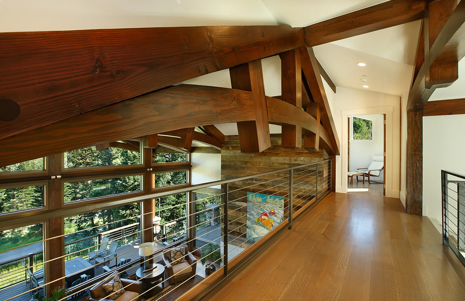 Loft hallway with a glass and cable stair railing overlooking the floor below