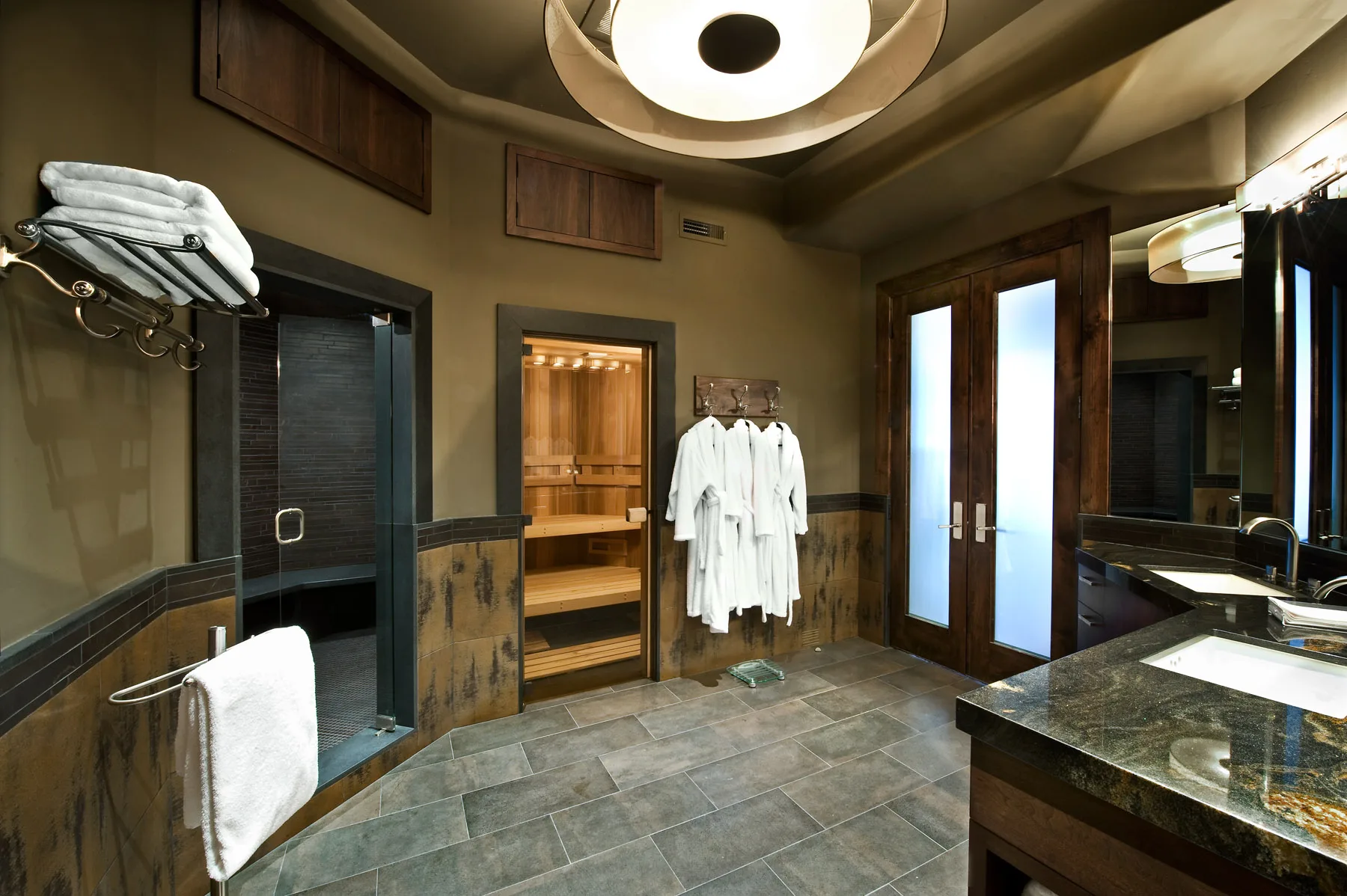 Dressing room with a round tray ceiling light and white robes hanging on hooks