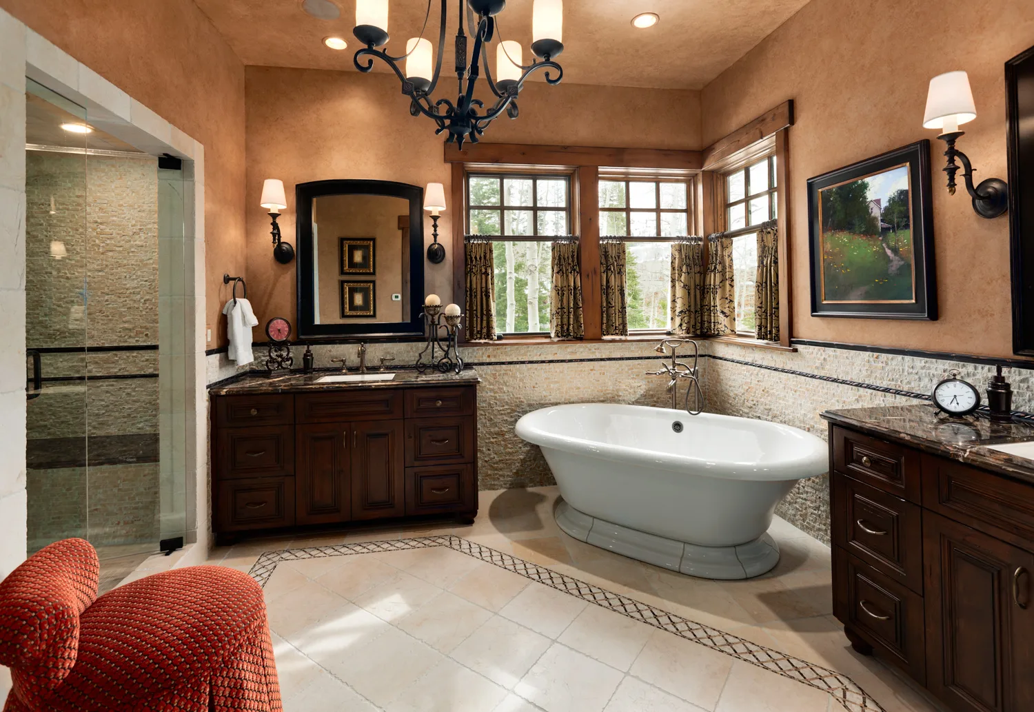 Bathroom with a freestanding tub, dark wood vanity and stone tile floor