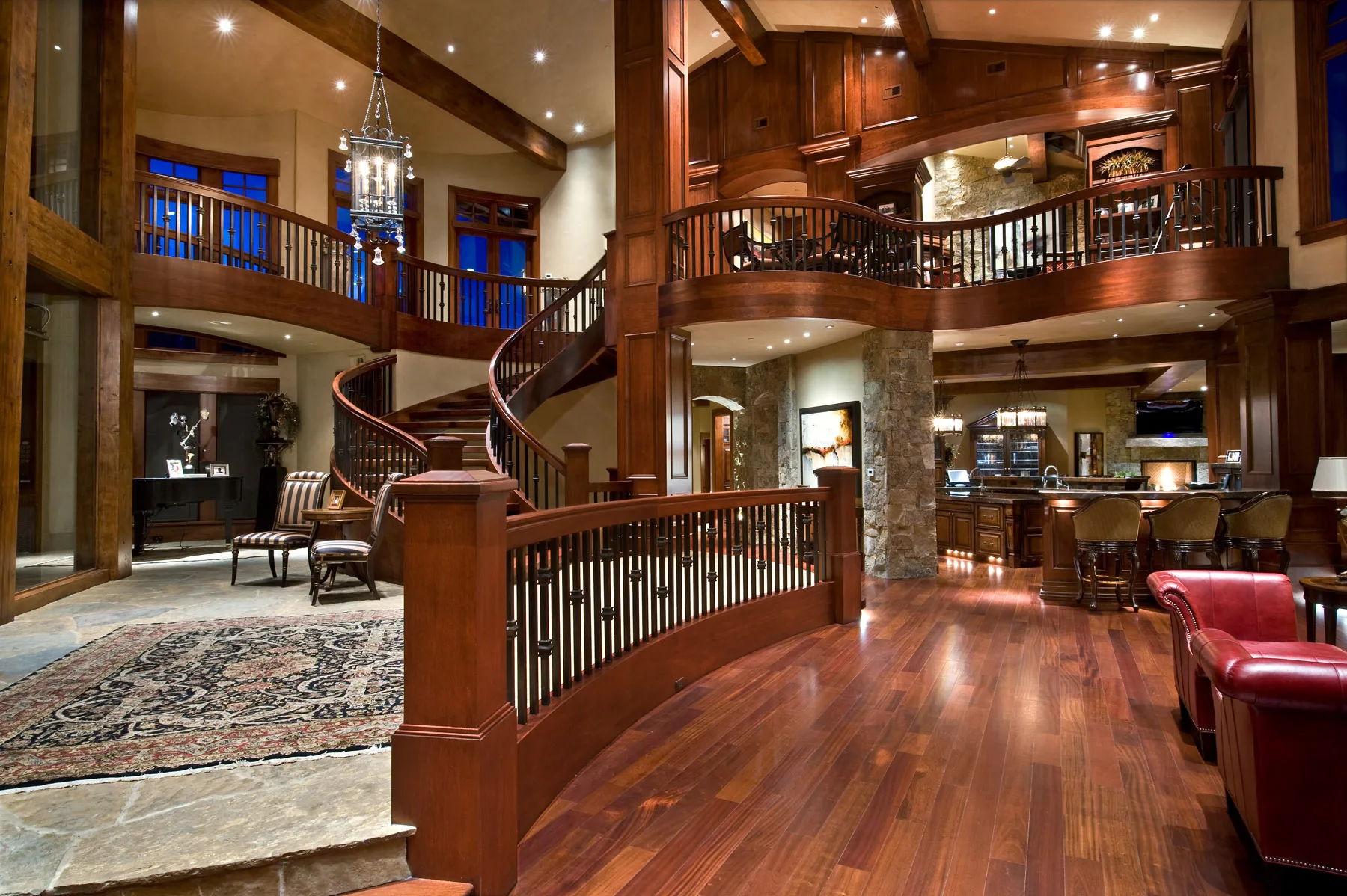 Curved wood staircase in a foyer with a window at the landing