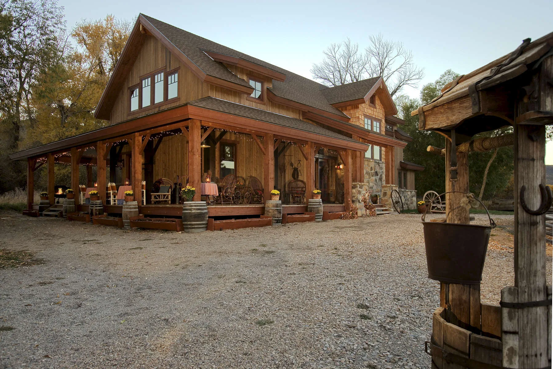 Timber-frame house exterior with a covered porch set in an autumn field