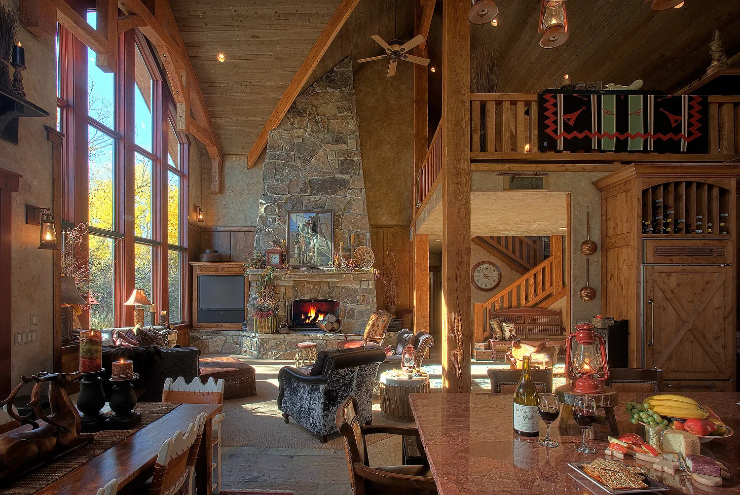 Living room with a stone fireplace, large windows and a mountain view
