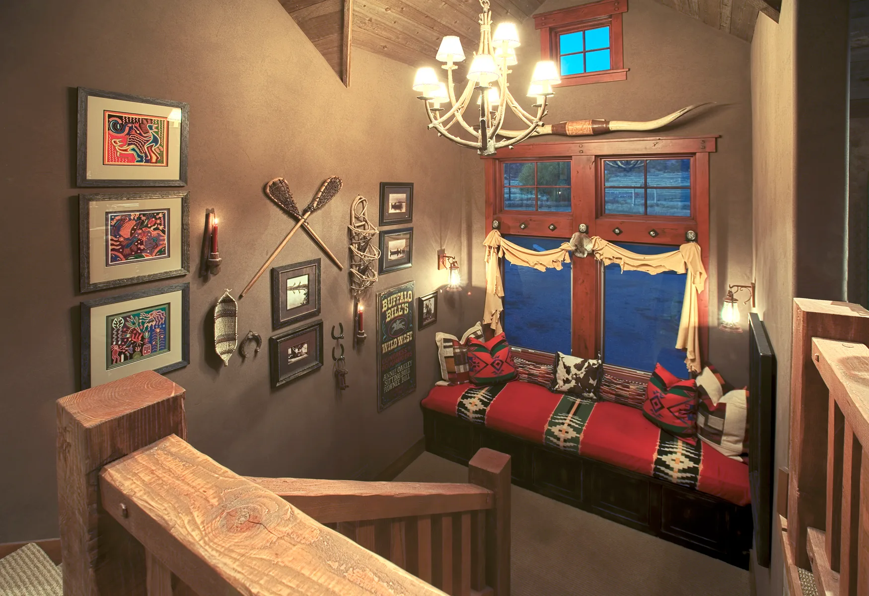 Bedroom with a four-poster style bed, red and blue bedding and framed wall art