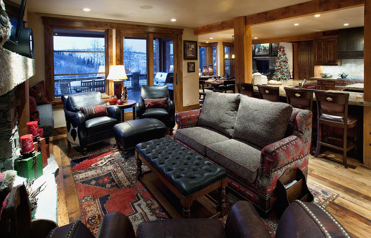 Living room with dark leather furniture, a fireplace and Christmas stockings hung nearby