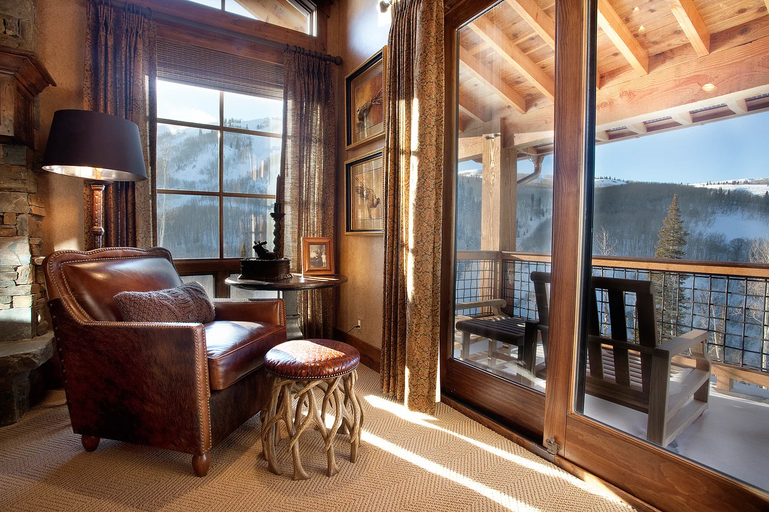 Covered deck with wood railings and seating overlooking a mountain view