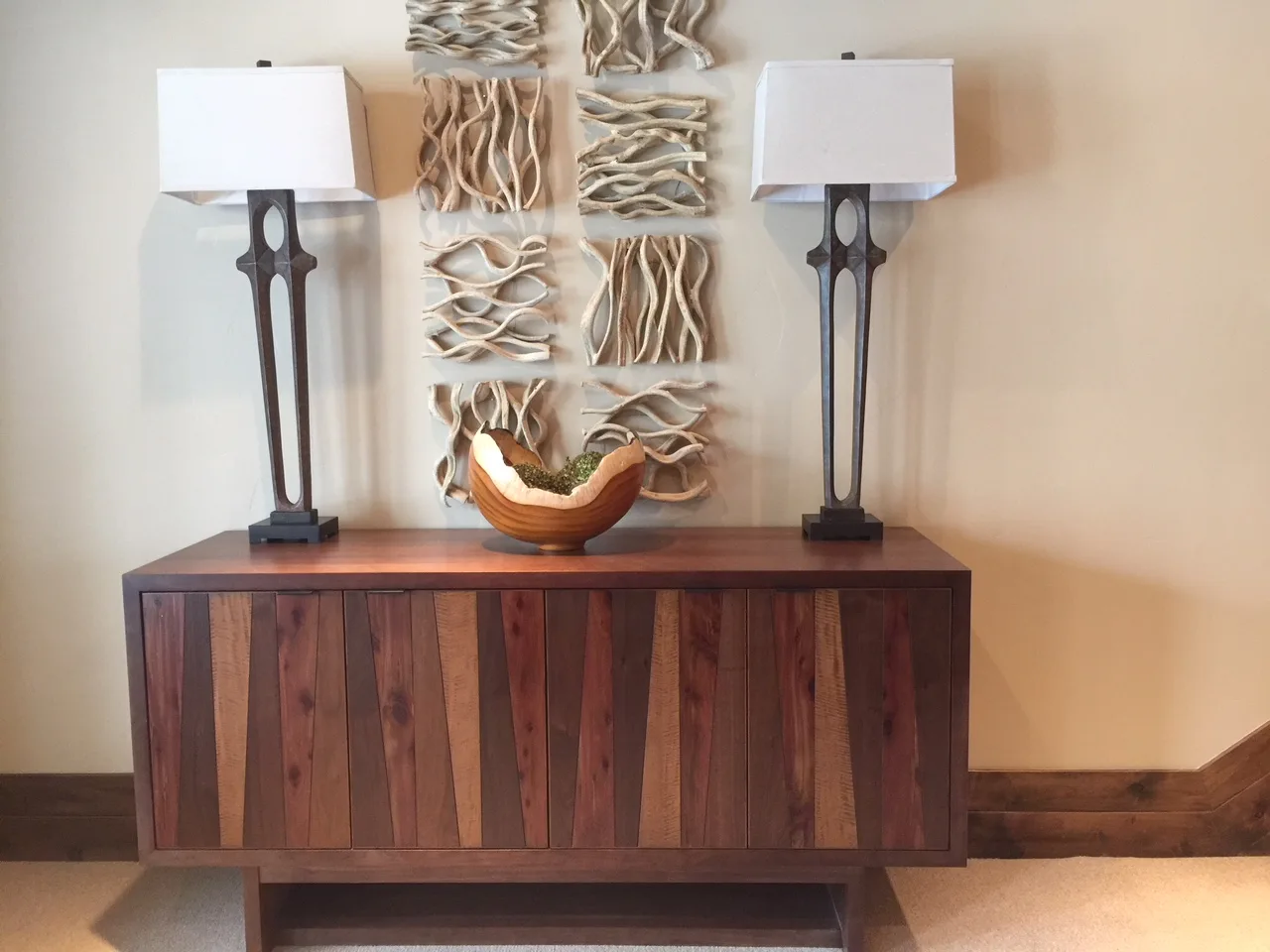 Custom wood sideboard with matching lamps and wall art hung above it