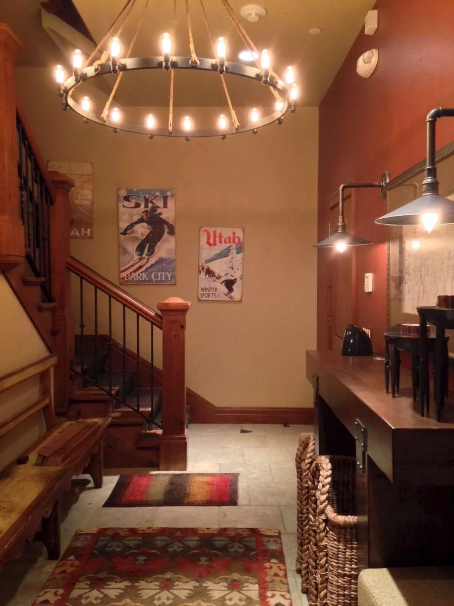 Wagon-wheel style chandelier in a room with red accent walls and vintage sign art