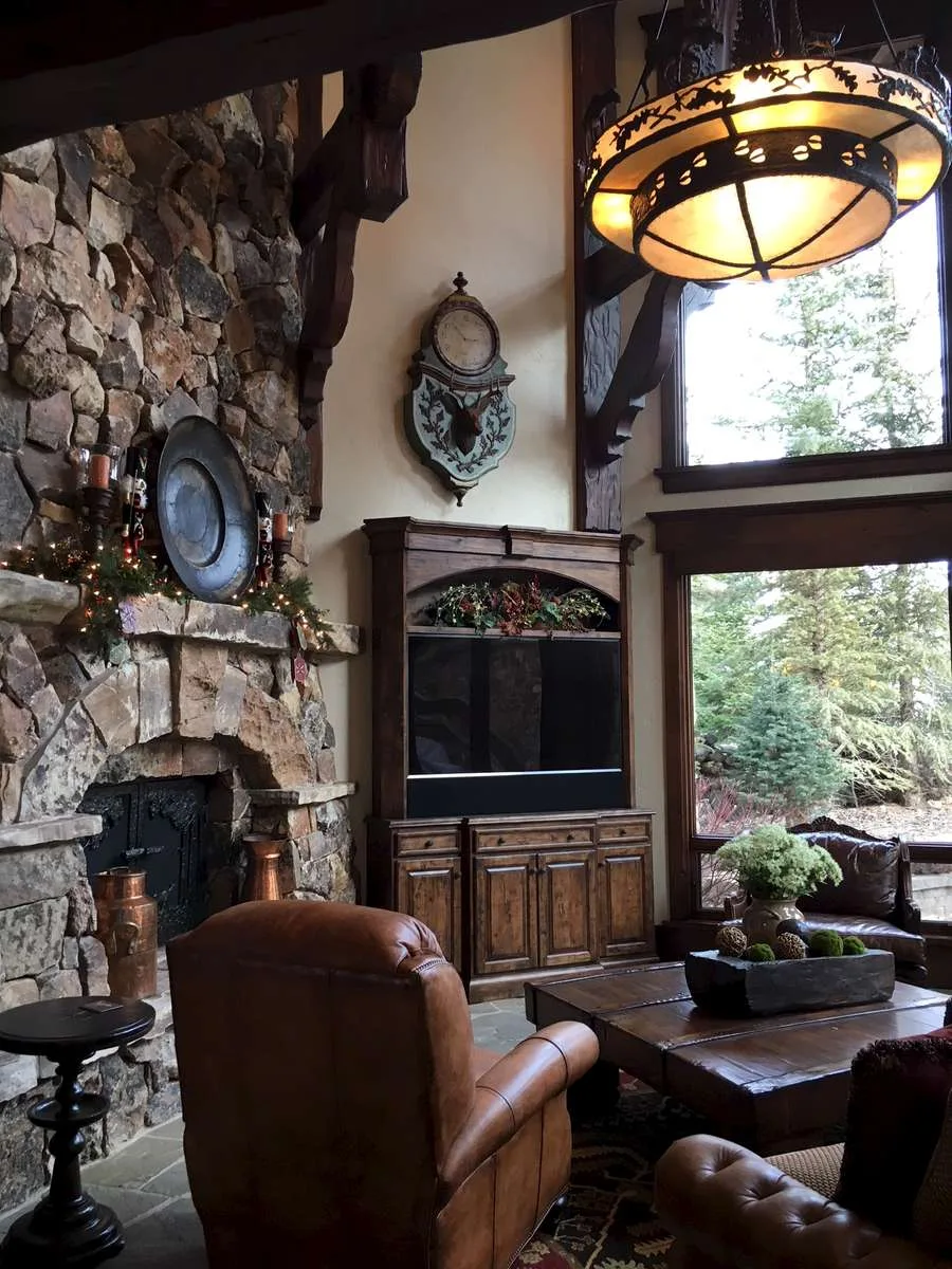 Stone fireplace with a built-in TV niche and a rustic chandelier above