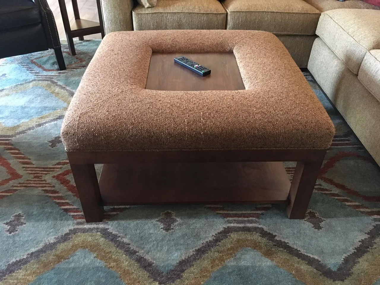 Custom square upholstered ottoman on a patterned area rug